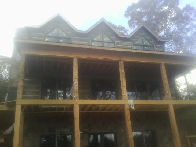 Dormers and porch framing on a large log home under construction — Roof Coating work by our crew in Ridgefield Park