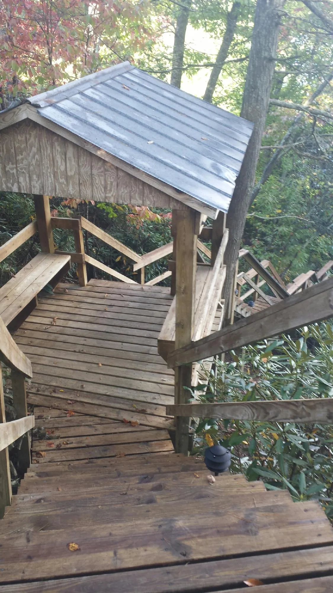 Metal roofed shelter over wooden steps on a wooded walkway — Skylight Repair & Installation work by our crew in Ridgefield Park