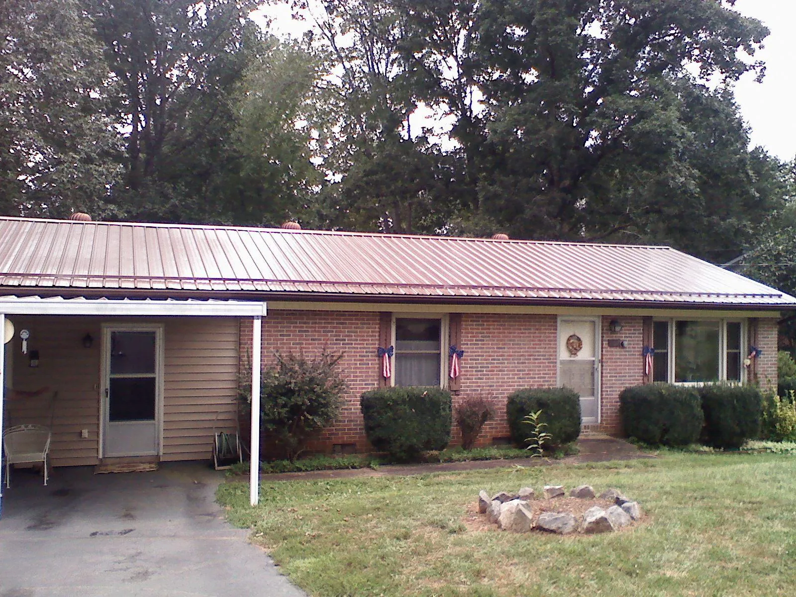 Bronze metal roof and carport on a brick ranch home — Roof Repair work by our crew in Ridgefield Park